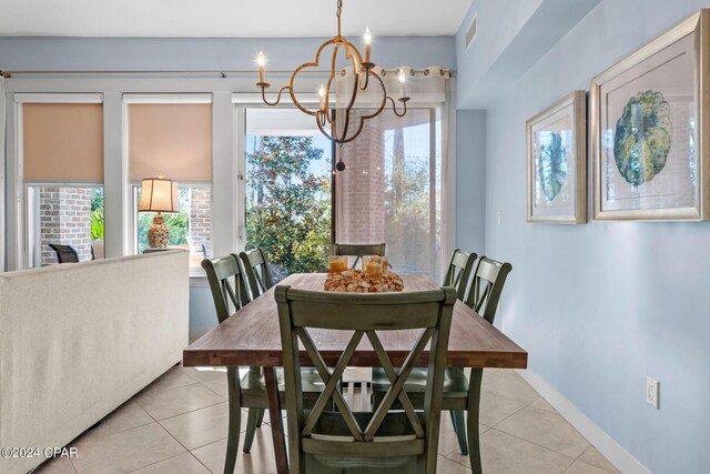 tiled dining room featuring a chandelier