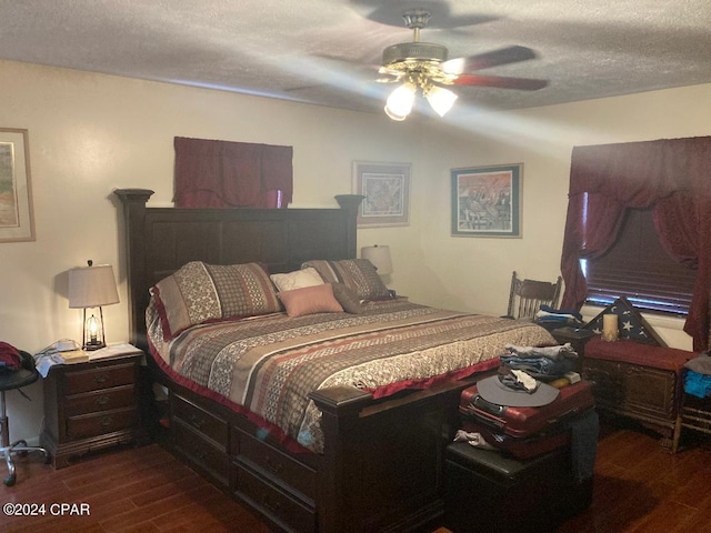 bedroom with a textured ceiling, ceiling fan, and dark wood-type flooring