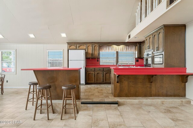 kitchen featuring light tile patterned flooring, sink, a breakfast bar area, and stainless steel appliances