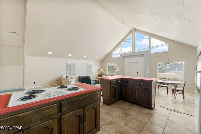 kitchen featuring light tile patterned flooring, a healthy amount of sunlight, dark brown cabinetry, and white appliances