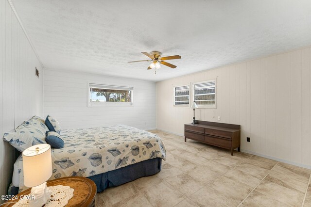 bedroom with light tile patterned flooring, a textured ceiling, and ceiling fan