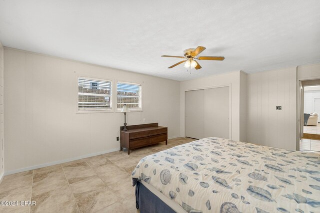 bedroom featuring light tile patterned flooring, ceiling fan, and a closet