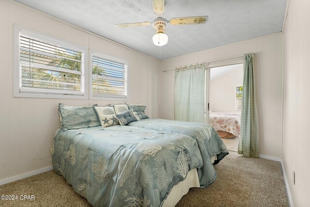 bedroom featuring light carpet, a textured ceiling, and ceiling fan