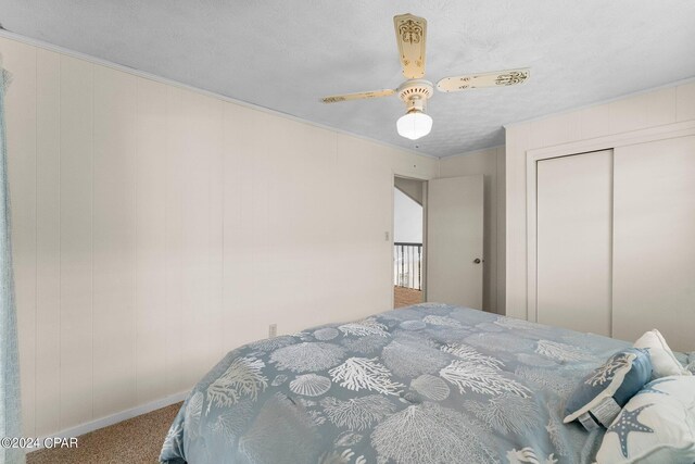 bedroom featuring a textured ceiling, ceiling fan, carpet flooring, and a closet