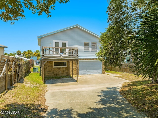 view of front of house featuring a balcony, central AC unit, and a garage