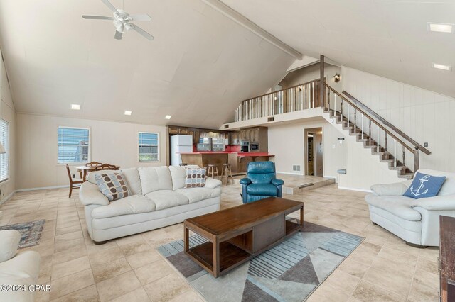 living room with light tile patterned floors, ceiling fan, and high vaulted ceiling