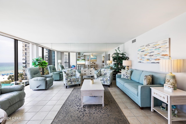 living room with floor to ceiling windows, a water view, and light tile patterned flooring