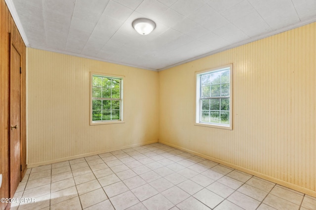 spare room with ornamental molding, light tile patterned flooring, and a healthy amount of sunlight