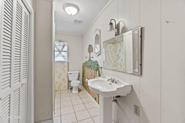 bathroom with crown molding, tile patterned floors, and toilet