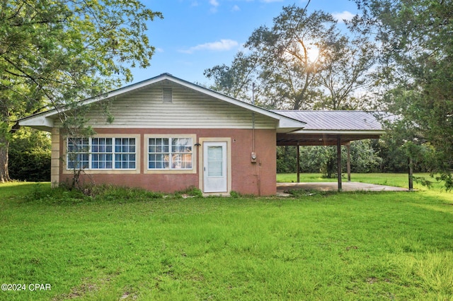 view of front of property with a front lawn and a carport