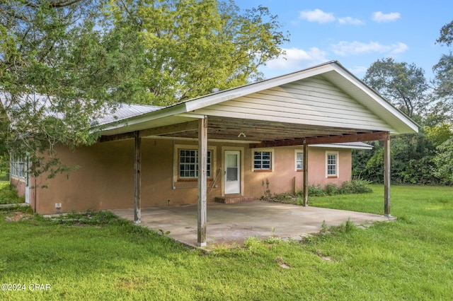 rear view of property with a lawn and a patio