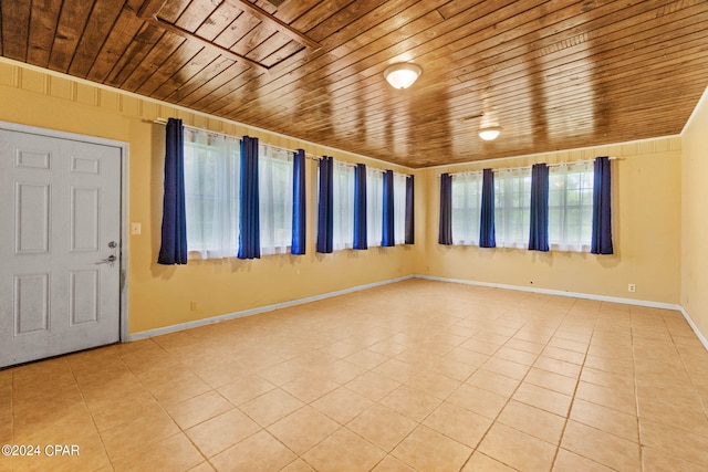 tiled spare room featuring wood ceiling