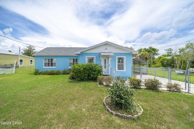 view of front of property featuring a front yard and a carport