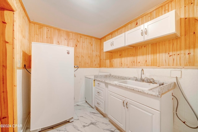 kitchen with sink, white fridge, white cabinetry, and light tile patterned floors