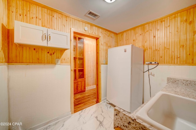 bathroom featuring tile walls, a bathtub, crown molding, sink, and wood-type flooring