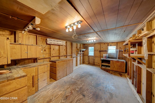 basement featuring wood walls and a wall mounted air conditioner