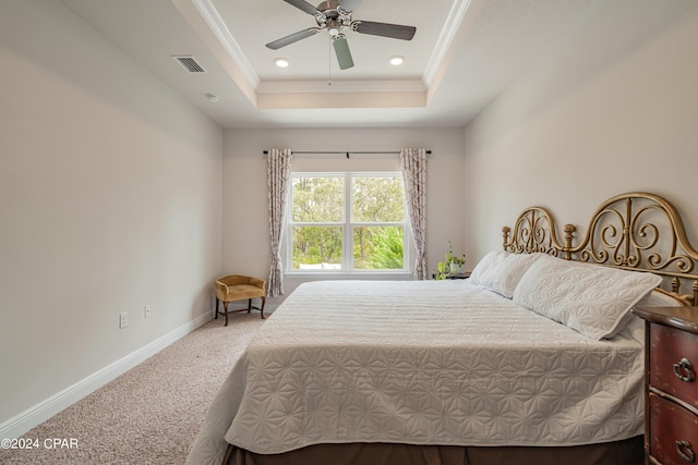 bedroom with ceiling fan, ornamental molding, a raised ceiling, and carpet floors