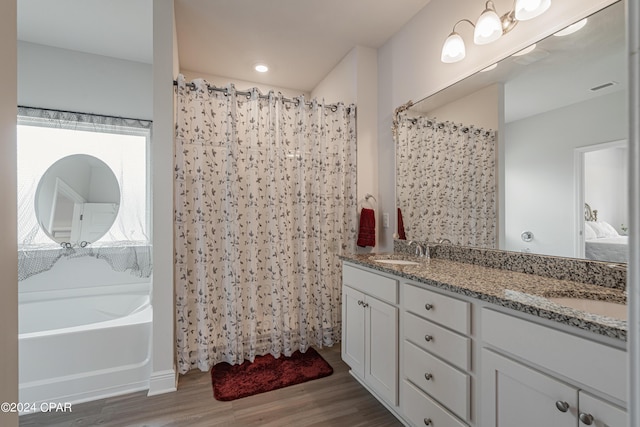 bathroom featuring vanity, a bath, and hardwood / wood-style flooring