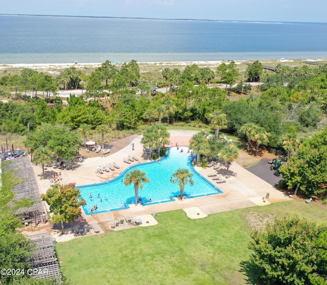 view of pool with a water view, a patio area, and a yard