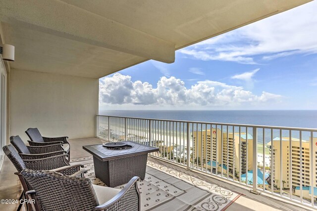 balcony with a water view and a view of the beach