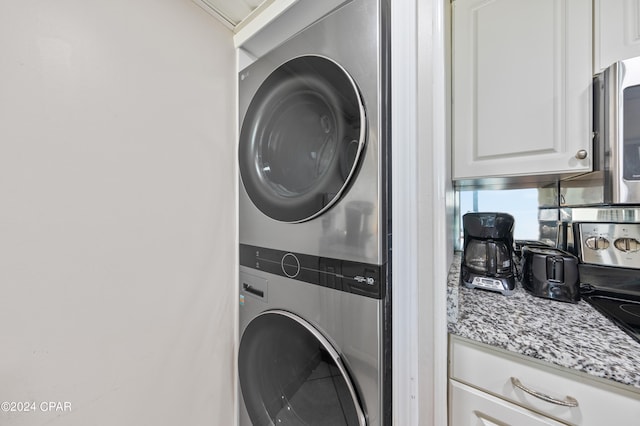 washroom with stacked washer / drying machine