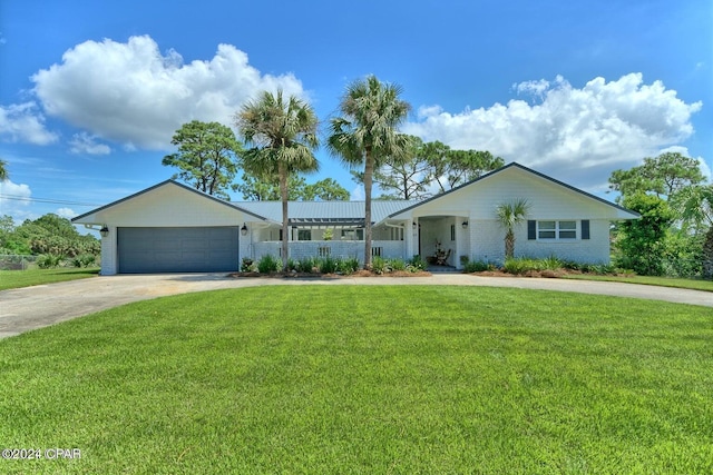 view of front of home with driveway, brick siding, an attached garage, and a front yard