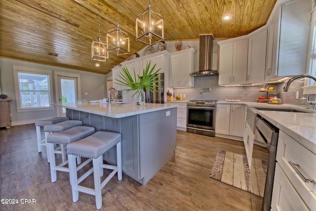 kitchen featuring stainless steel gas stove, a sink, wall chimney range hood, wooden ceiling, and dishwashing machine