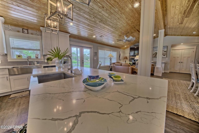 kitchen with lofted ceiling, a sink, wood ceiling, and dark wood-style floors