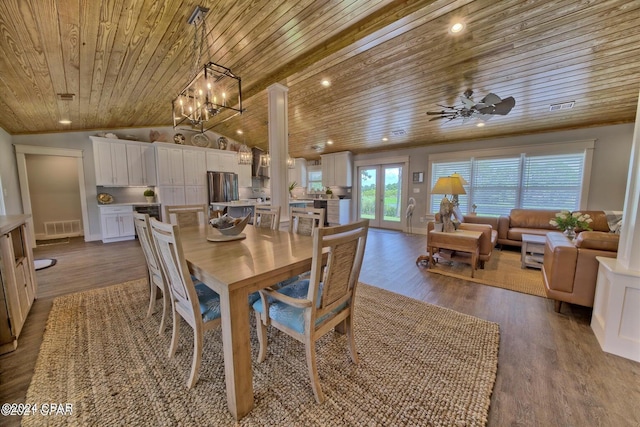 dining space with visible vents, vaulted ceiling, and wood finished floors