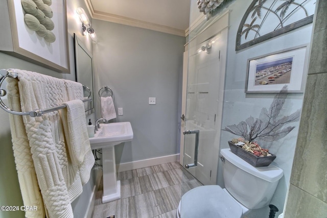 half bathroom featuring ornamental molding, toilet, and baseboards