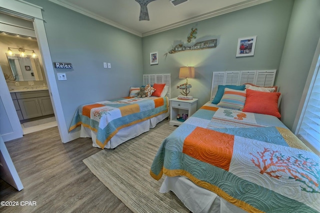 bedroom with ensuite bathroom, wood finished floors, visible vents, and crown molding