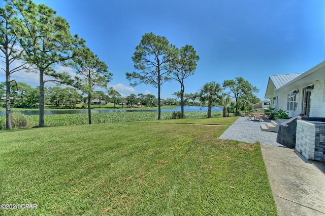 view of yard with a water view and a patio area