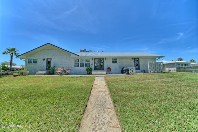 single story home with entry steps, brick siding, and a front yard