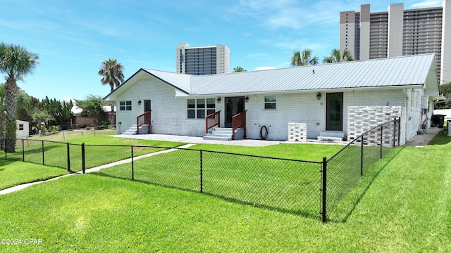 view of front of house featuring entry steps, a chimney, a front lawn, and brick siding