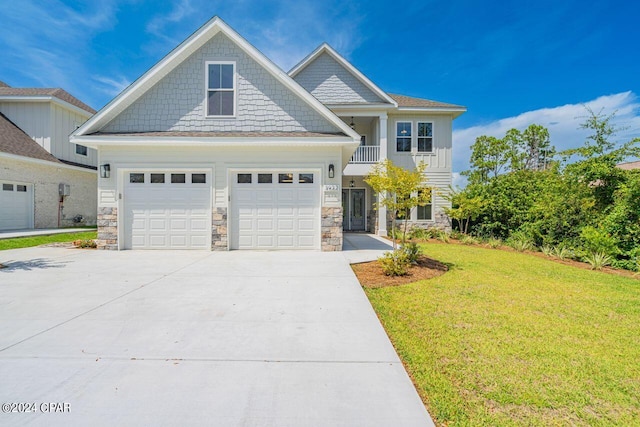 craftsman inspired home with a garage, a balcony, and a front lawn