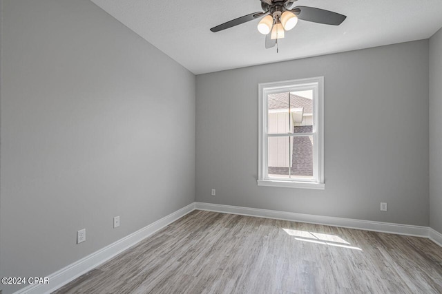 empty room with a textured ceiling, light hardwood / wood-style flooring, and ceiling fan