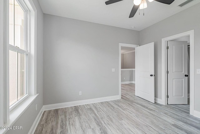 empty room featuring ceiling fan, light hardwood / wood-style floors, and a healthy amount of sunlight