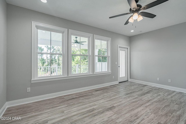 unfurnished room featuring ceiling fan, light hardwood / wood-style floors, and a healthy amount of sunlight