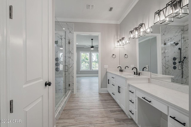 bathroom featuring hardwood / wood-style floors, vanity, ornamental molding, an enclosed shower, and ceiling fan