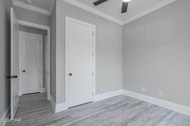 unfurnished bedroom with ornamental molding, light wood-type flooring, and ceiling fan