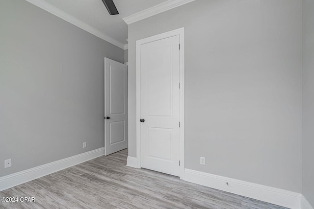 spare room featuring crown molding, ceiling fan, and light wood-type flooring