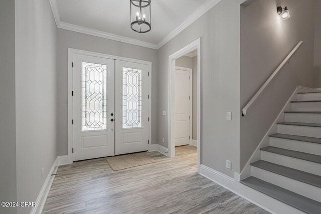 foyer featuring crown molding, light hardwood / wood-style floors, and french doors