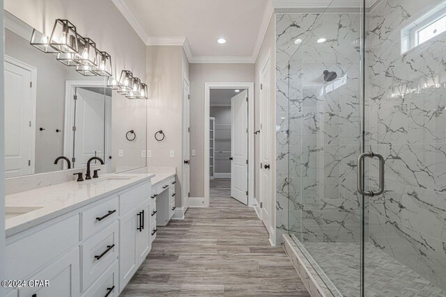 bathroom with ornamental molding, hardwood / wood-style floors, vanity, and a shower with shower door