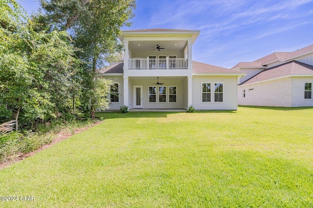 rear view of house featuring a lawn, a balcony, and ceiling fan