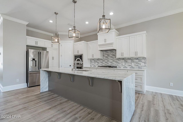 kitchen featuring appliances with stainless steel finishes, light hardwood / wood-style flooring, sink, backsplash, and white cabinetry