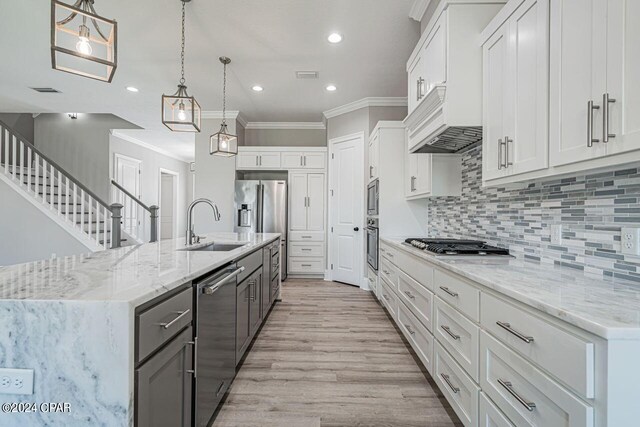 kitchen featuring sink, white cabinetry, backsplash, and light hardwood / wood-style floors