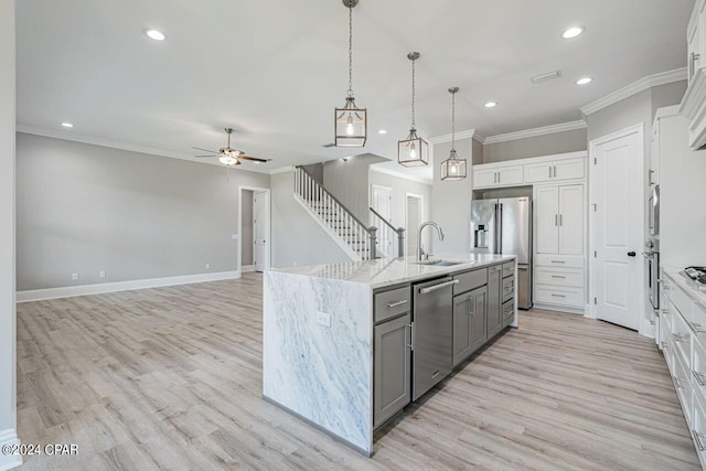 kitchen featuring appliances with stainless steel finishes, sink, gray cabinets, light hardwood / wood-style floors, and white cabinetry