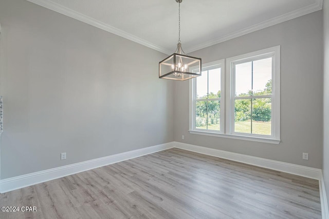 empty room featuring ornamental molding, light wood-type flooring, and a chandelier