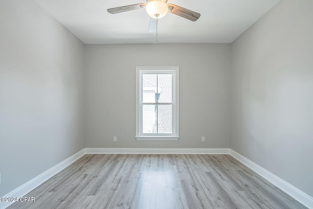 spare room with light wood-type flooring and ceiling fan