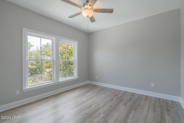 empty room with ceiling fan and light hardwood / wood-style floors